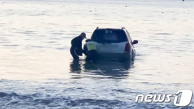 31일 오전 6시30분쯤 경북 포항시 북구 영일대해수욕장 인근인 두호 해변 백사장에 주차돼 있던 SUV차량이 파도에 밀려 바다에 빠졌다는 신고를 받고 출동한 포항해양경찰서 직원들이 견인 작업을 준비하고 있다. 차량에는 사람이 없어 인명피해는 발생하지 않았다.(포항해양경찰서제공)2021.1.31/뉴스1 © News1 최창호 기자