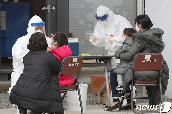 28일 경북 안동시보건소에 마련된 선별진료소에서 어린이를 동반한 가족이 신종 코로나바이러스 감염증(코로나19) 진단검사를 받고 있다. 안동의 태권도학원발 코로나19 확진자가 지난 26일 이후 42명으로 늘어나 방역에 비상이 걸렸다. 2021.1.28/뉴스1 © News1 공정식 기자