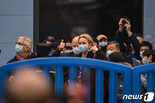 세계보건기구(WHO) 조사팀이 현장에 설치된 바리케이드를 넘어 우한 화난 수산물시장에 들어가고 있다. © AFP=뉴스1