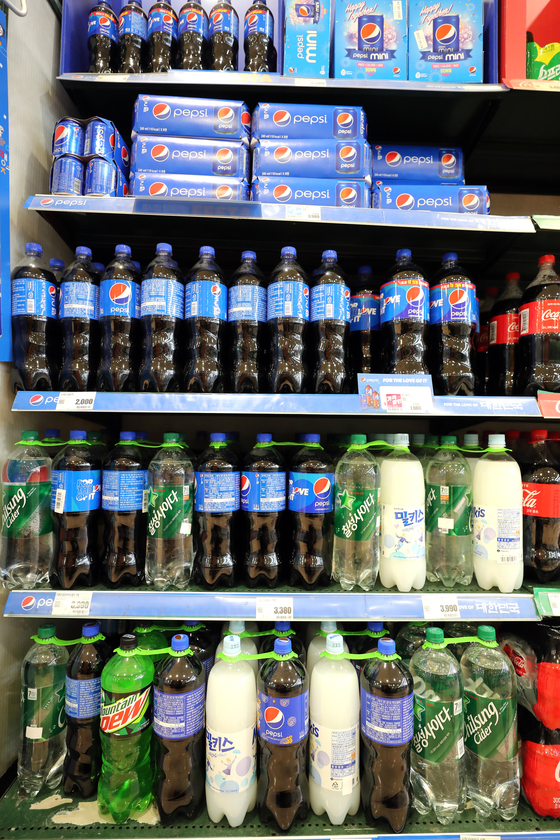 Soft drinks are displayed on the shelves of a supermarket in Seoul on Sunday. The prices of popular beverages will go up starting Monday. The price of Chilsung Cider will jump by 6.6 percent and Pepsi up 7.9 percent. [YONHAP]