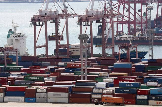 Cargo containers filled with export products are loaded onto ships at a dock in the Port of Busan, in the city’s Nam District. (Yonhap News)