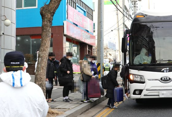 지난달 25일 대전시 중구 대흥동 IEM국제학교에서 신종 코로나바이러스 감염증(코로나19) 확진자들이 충남 아산 생활치료센터로 이동하기 위해 차량에 탑승하고 있다. 연합뉴스