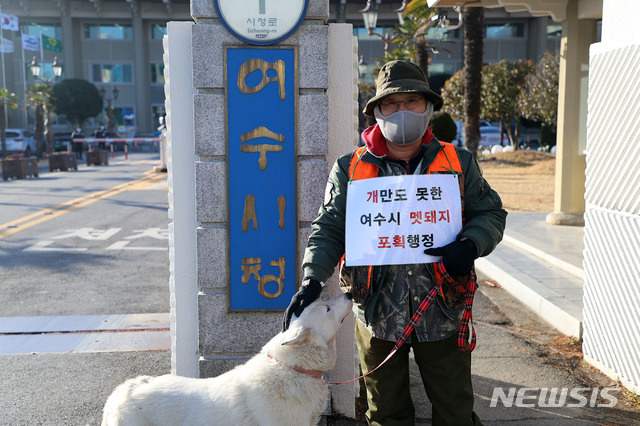 [여수=뉴시스]김석훈 기자 = 전남 여수시 유해조수관리협의회 회원이 2일 여수시청 정문에서 사냥개를 끌고 나와 여수시의 유해조수퇴치 행정의 부당성을 알리고 제도 개선을 촉구하는 1인시위를 하고 있다. (사진=독자 제공) 2021.02.02. photo@newsis.com