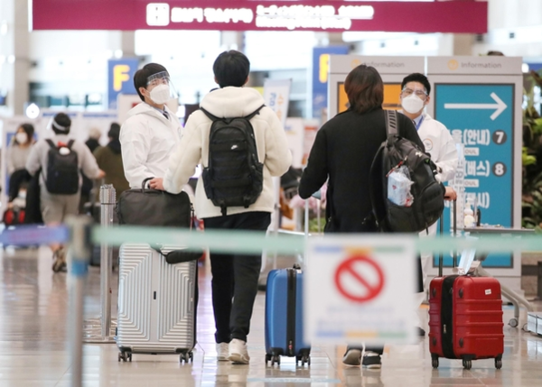 지난달 19일 인천국제공항 제1터미널 입국장에서 해외입국자들이 방역관계자로부터 안내를 받고 있다. /연합뉴스