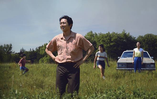 This image released by A24 shows Steven Yeun, foreground, in a scene from "Minari." (A24-AP)