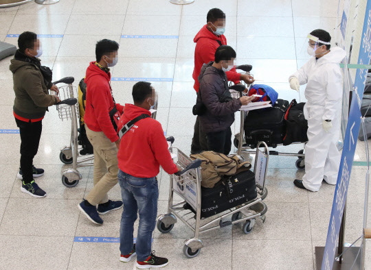 영국발 변이 바이러스의 첫 지역사회 집단감염 사례가 발생한 가운데 4일 오전 인천국제공항 제1터미널에서 방역관계자가 해외입국자에게 길을 안내하고 있다. 연합뉴스