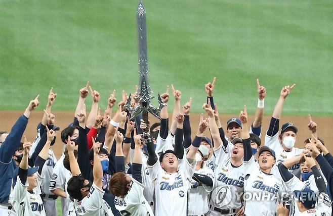 지난해 11월 24일 프로야구 한국시리즈를 우승한 NC 다이노스 선수들이 '리니지'의 최고가 아이템 집행검의 실물을 들어올리며 승리를 자축하던 모습. 최근 엔씨는 '리니지2M'에도 집행검 같은 '신화 무기'를 출시했는데, 아이템을 뽑을 수 있는 확률을 투명하게 공개하지 않고 있어 논란이 일고 있다.[연합뉴스 자료사진]