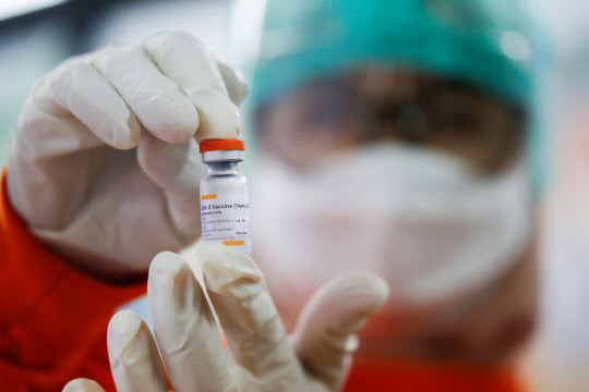 인도네시아 수도 자카르타의 한 의료시설에서 의료진이 중국 시노백사의 코로나19 백신을 들어 보이고 있다. 인도네시아는 내년 3월까지 전체 인구의 70%인 1억8150만 명에게 백신을 맞힐 계획이다. <로이터=연합뉴스>
