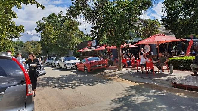 모처럼 날이 개자 사람들로 붐비는 커피숍, 식당 거리 (프리토리아=연합뉴스) 김성진 특파원 = 5일 오후 모처럼 드물게 햇살이 내리쬐는 주말을 맞아 프리토리아 시내 커피숍, 식당가가 사람들로 붐비고 있다. 2021.2.6 sungjin@yna.co.kr