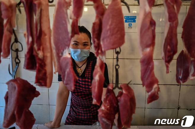 지난 8월5일 중국 우한의 한 시장에서 한 여성이 마스크를 쓰고 정육점을 지키고 있다. © AFP=뉴스1 © News1 권영미 기자