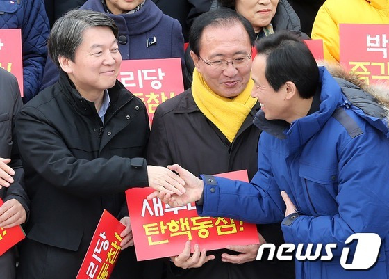 우상호 더불어민주당 원내대표와 안철수 전 국민의당 대표가 7일 오후 서울 여의도 국회에서 열린 박근혜 대통령 탄핵을 위한 야3당 결의대회에서 악수를 하고 있다(본문과 관련없음). 2016.12.7/뉴스1 © News1 손형주 기자