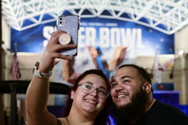 미국프로풋볼(NFL) 챔피언 결정전 슈퍼볼 개최지인 미국 플로리다주 탬파에서 경기를 하루 앞둔 6일(현지시간) 밤 시민들이 축제 현수막 앞에서 사진을 촬영하고 있다. AFP연합뉴스