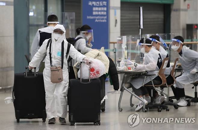 입국장 나서는 해외입국객들 (영종도=연합뉴스) 임헌정 기자 = 영국발 신종 코로나바이러스 감염증(코로나19) 변이 바이러스로 4차 유행에 대한 우려가 커지는 가운데 지난 5일 영종도 인천국제공항에서 방역복을 입은 해외 입국자들이 입국장을 나서고 있는 모습. [연합뉴스 자료사진]