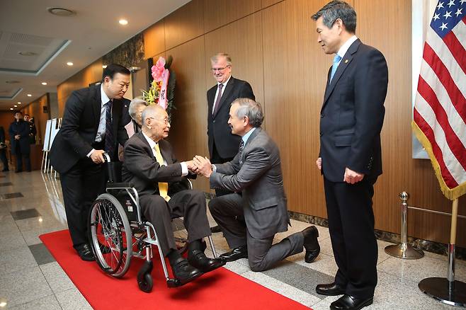 2018년 11월 21일 서울 용산구 국방컨벤션에서 주한미군이 주관한 백선엽 장군(왼쪽 둘째) 생일 파티에서 해리 해리스(오른쪽) 당시 주한 미 대사가 무릎을 꿇고 백 장군을 맞이하고 있다./남강호 기자