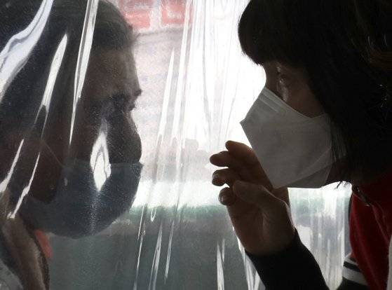 설날인 12일 오후 울산시 울주군 이손요양병원에 설치된 비닐 면회실에서 며느리가 비닐막 너머 앉은 시어머니를 면회하고 있다.뉴스1