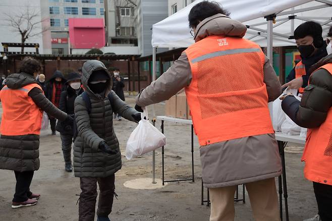 지난달 27일 오후 서울 중구 무료급식소 '명동밥집'에서 자원봉사자들이 회현동 골목식당에서 만든 도시락을 받고 있다. / 고운호 기자