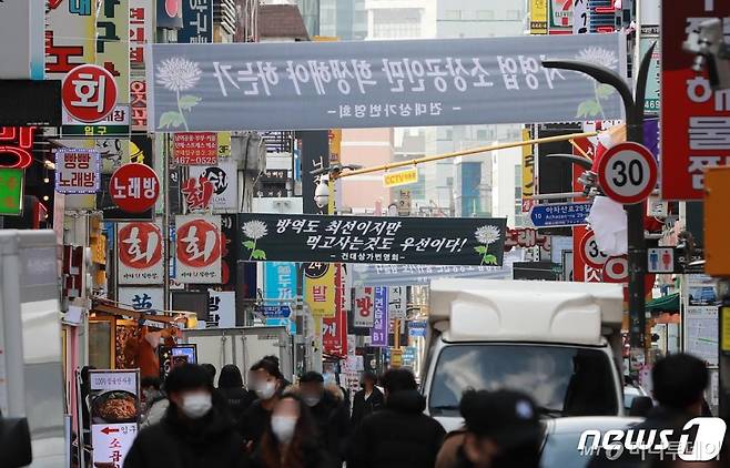 (서울=뉴스1) 구윤성 기자 = 3일 오후 서울 광진구 건대맛의거리에 '정부의 사회적 거리두기'를 비판하는 검은색 현수막이 걸려 있다. 최근 자영업자들을 중심으로 집합금지 및 영업제한 업종 간 형평성 문제와 특정 집단의 불만섞인 목소리가 커지면서 중앙사고수습본부는 지난 2일 '사회적 거리두기 체계 개편 공개토론회'를 개최했다. 또 오는 9일에는 자영업·소상공인 관계자들과 함께 다중이용시설 방역수칙 적용에 대한 방안을 논의할 예정이다. 2021.2.3/뉴스1