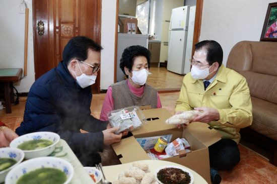 (우측)신우철 군수가 설 명절 음식 나누고 주민들과 대화를 하고 있다. (사진=완도군 제공)