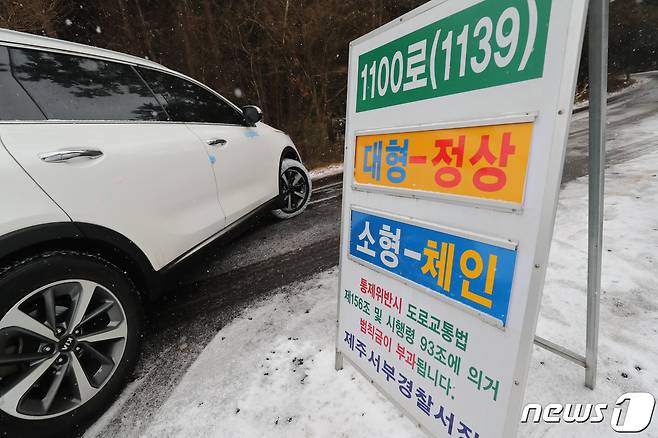 제주 한라산 1100도로에서 소형 차량들이 체인을 장착한 후 진입하고 있다. 2020.12.14 /뉴스1 © News1 오현지 기자