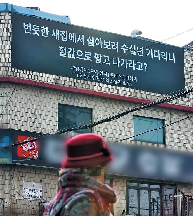 서울 용산구 동자동의 한 건물 외벽에 '서울역 쪽방촌 공공주택 사업'에 반대하는 토지·건물주들이 현수막을 내걸었다. 이들은 "정부가 사전 협의 없이 개발 계획을 기습적으로 발표했다"며 "공공의 이익이란 명분으로 사유재산권을 박탈한 것"이라고 반발하고 있다. /연합뉴스