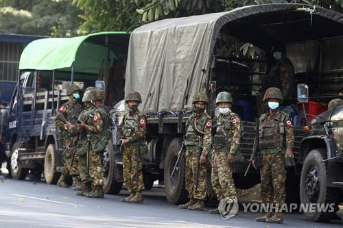 지난 15일(현지시간) 미얀마 양곤 NLD 당사 앞에 군인들이 주차된 트럭 옆에 서있다. /AP연합뉴스