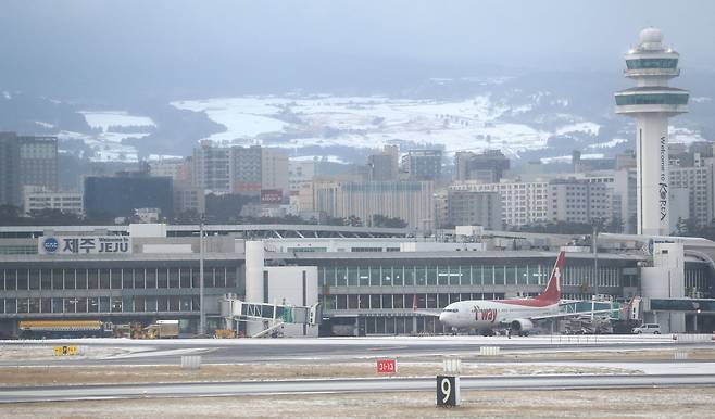 제주에 강풍과 폭설이 몰아친 18일 오전 제주국제공항 뒤편으로 눈 쌓인 중산간 목장지대가 보인다. 연합뉴스