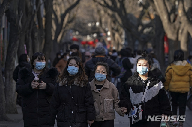 [베이징=AP/뉴시스] 설 연휴기간인 16일 중국 베이징 도심에서 행인들이 마스크를 쓰고 걸어가고 있다. 2021.02.17