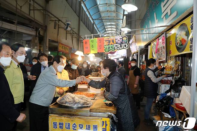 설 명절을 하루 앞둔 10일 오후 광주 서구 양동시장에서 정세균 국무총리가 '노무현 국밥집'으로 유명한 한 식당 앞에서 상인과 인사를 나누고 있다.2021.2.10/뉴스1 © News1 허단비 기자