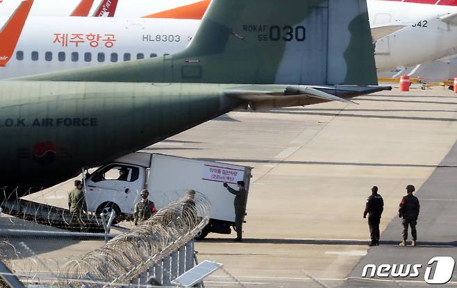 군 당국과 유관기관 관계자들이 19일 오후 제주국제공항에서 군 수송기를 투입한 신종 코로나바이러스 감염증(코로나19) 백신 안전유통 모의훈련을 실시하고 있다.2021.2.19/뉴스1 © News1 오현지 기자