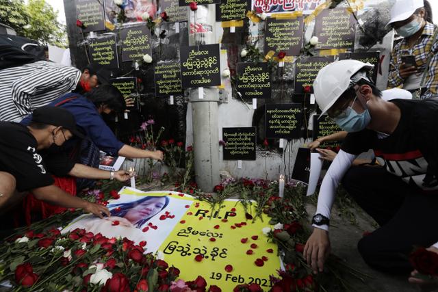 미얀마 최대 도시 양곤에서 20일 시민들이 쿠데타 규탄 시위 중 총에 맞아 숨진 스무살 여성 먀 뚜웨 뚜웨 킨을 추모하며 피격 현장의 추모소에 꽃과 촛불을 놓고 있다. 양곤=EPA 연합뉴스