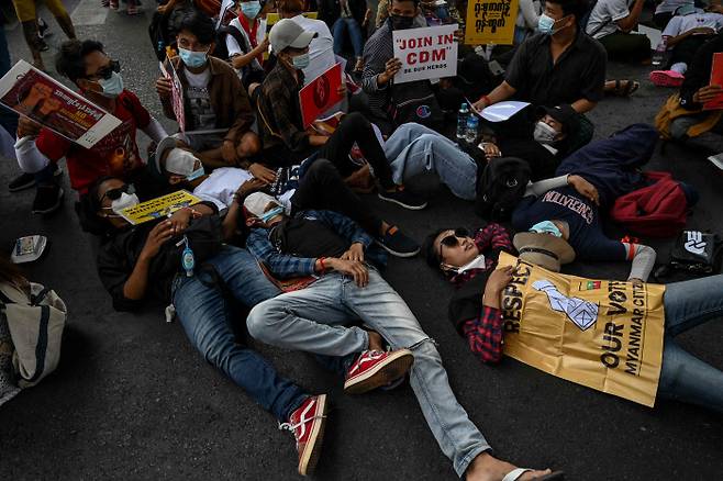 미얀마 양곤에서 20일(현지시간) 쿠데타 반대 시위대가 거리에 누워 길을 막고 있다. AFP연합뉴스