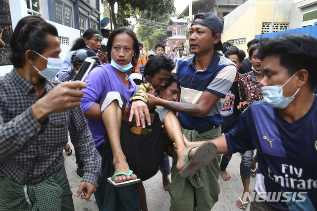 [만달레이=AP/뉴시스]20일 미얀마 제2도시 만달레이에서 군부 쿠데타에 항의하는 시위에 참여한 한 남성이 군경이 쏜 총에 맞아 실려가고 있다. 2020.02.20.