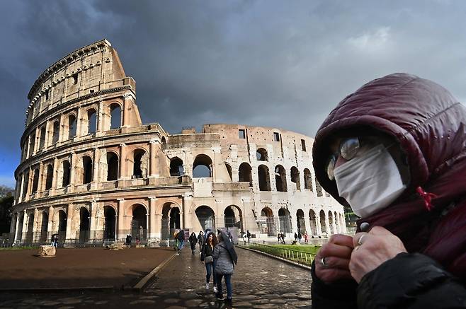 지난해 3월 방역 마스크를 쓴 남성이 이탈리아 로마 콜로세움을 지나고 있다. AFP=연합뉴스