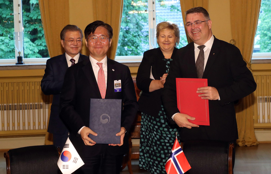 Sung Yun-mo, left, then-minister of trade, industry and energy of Korea, with Kjell-Børge Freiberg, Norwegian minister of petroleum and energy at the time, after signing an agreement on hydrogen economy and low-carbon technologies at the residence of Norwegian Prime Minister Erna Solberg on June 13, 2019. Behind them are Prime Minister Solberg, right, with Korea's President Moon Jae-in, left. [JOINT PRESS CORPS OF THE BLUE HOUSE]