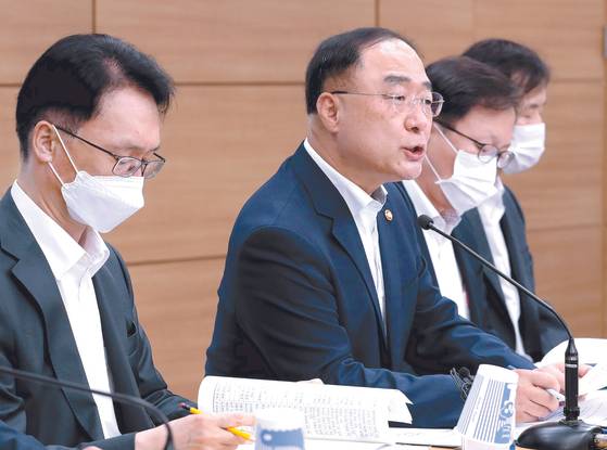 Finance Minister Hong Nam-ki, second from left, announces the government's tax reform plans during a briefing held at the Sejong Government Complex in July last year. [YONHAP]