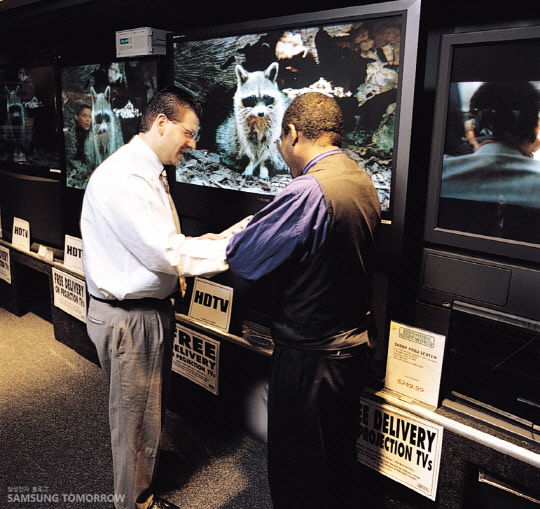 미국의 한 매장에서 소비자가 1998년 우주왕복선 디스커버리 호 발사 장면을 전 세계로 중계한 삼성전자 디지털 TV를 살펴보고 있다. <삼성전자 제공>