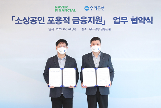 Woori Bank CEO Kwon Kwang-seok, right, and Naver Financial CEO Choi In-hyuk pose for a photo after inking a partnership to offer specialized loans for small online sellers on Wednesday at Woori Bank's main branch in Jung District, central Seoul. [NAVER FINANCIAL]