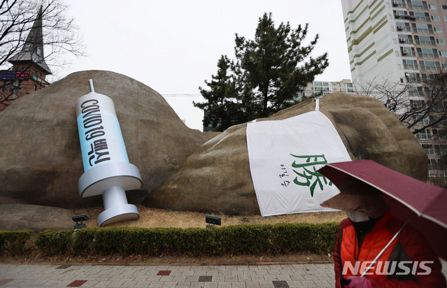 [대구=뉴시스] 이무열 기자 = 신종 코로나바이러스 감염증(코로나19) 백신 국내 접종 시작을 하루 앞둔 25일 오후 대구 달서구 진천동 선사유적공원 입구 원시인 조형물에 대형 주사기가 설치돼 눈길을 끌고 있다. 2021.02.25. lmy@newsis.com