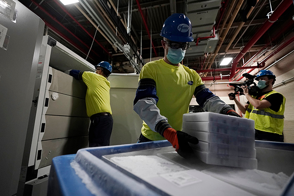 미국 미시간주 포티지에 있는 화이자 공장에서 2020년 12월 13일(현지시간) 직원들이 화이자·바이오앤테크의 코로나19 백신 상자를 운송용기에 싣고 있다. EPA/연합뉴스 제공