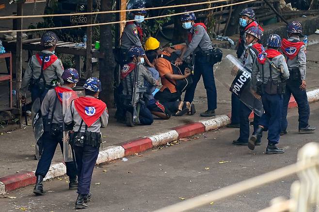 27일 미얀마 최대 도시 양곤에서 현지 경찰이 시위대를 체포하고 있다. AFP연합뉴스.