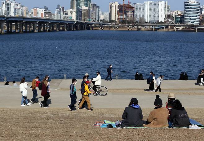 포근한 날씨가 이어지는 26일 오후 서울 영등포구 여의도한강공원에서 시민들이 휴식을 취하고 있다. 연합뉴스