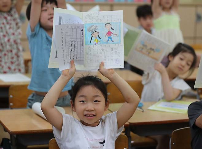 19일 오전 서울 강남구 봉은초등학교에서 1학년 4반 학생들이 여름방학 숙제로 받은 그림일기를 번쩍 들며 방학숙제를 잘 해오겠다고 약속하고 있다. 백소아 기자