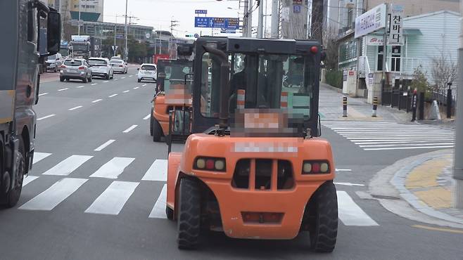 부산의 한 도로를 지게차들이 달리고 있습니다.