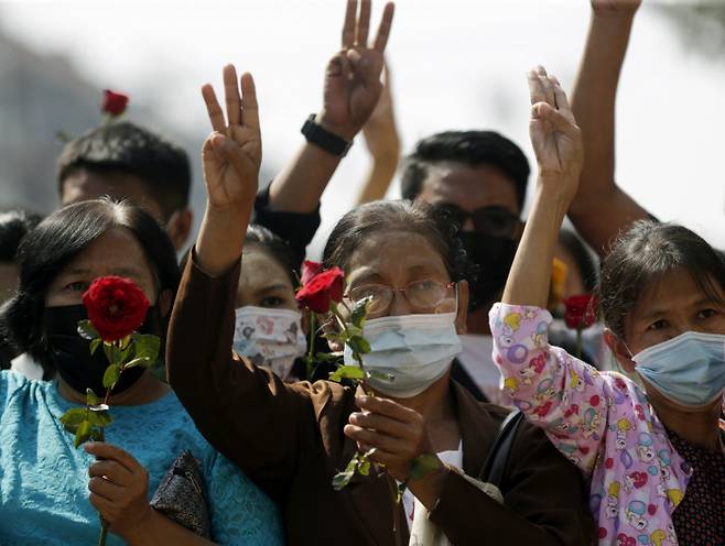 미얀마 양곤에서 1일 시민들이 미얀마 군경의 강경 진압으로 숨진 시위대를 추모하는 집회를 열면서 꽃 한 송이를 손에 든 채 민주화 시위의 상징인 세 손가락을 들어보이고 있다. 양곤/EPA연합뉴스
