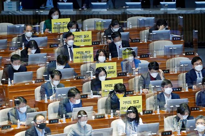 정의당 의원들이 26일 오후 국회에서 열린 제384회국회(임시회) 7차 본회의에서 가덕도 관련 법안을 비판하는 피켓을 의석에 붙여 놓고 있다. 윤창원 기자