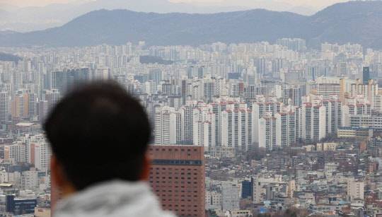 한 시민이 도심 아파트 밀집 지역을 바라보고 있다. <연합뉴스>