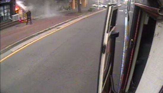 버스기사 김상남(55)씨가 지난달 27일 오전 8시50분께 운행 중 상가 화재를 목격하고 버스 뒷좌석에 있던 소화기로 불을 끄고 있다. 사진=제주여객 제공 영상 캡처