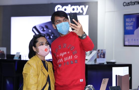 Customers in India look at Samsung Electronics' new Galaxy S21 at an exhibition hall inside the Ambience Mall, Gurugram, India. [SAMSUNG ELECTRONICS]