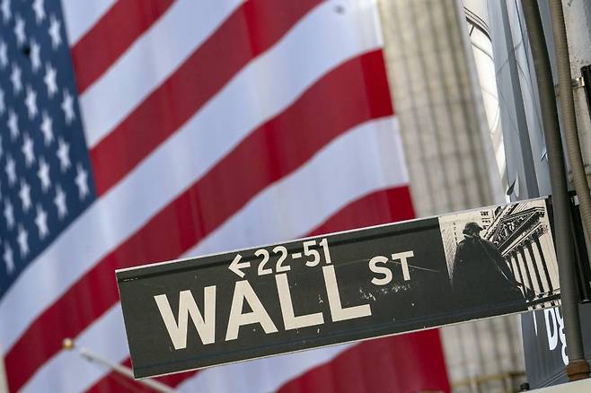 FILE - In this Monday, Sept. 21, 2020, file photo, a Wall Street street sign is framed by a giant American flag hanging on the New York Stock Exchange in New York. Stocks are falling in early trading on Wall Street Monday, Oct. 26, 2020, and deepening last week’s losses. (AP Photo/Mary Altaffer, File) / 사진제공=AP 뉴시스