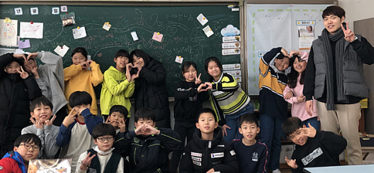 경기 의정부 솔뫼초등학교 강용모(오른쪽) 교사가 신종 코로나바이러스 감염증(코로나19) 유행 전인 지난해 초 담임을 맡은 4학년 학생들과 기념촬영을 하고 있다.  초록우산어린이재단 제공